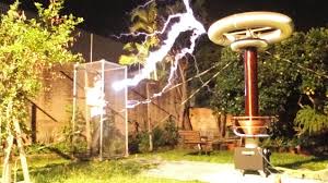 Hombre en una jaula de Faraday donde no entra el campo eléctrico generado en el aire por una bobina de tesla 